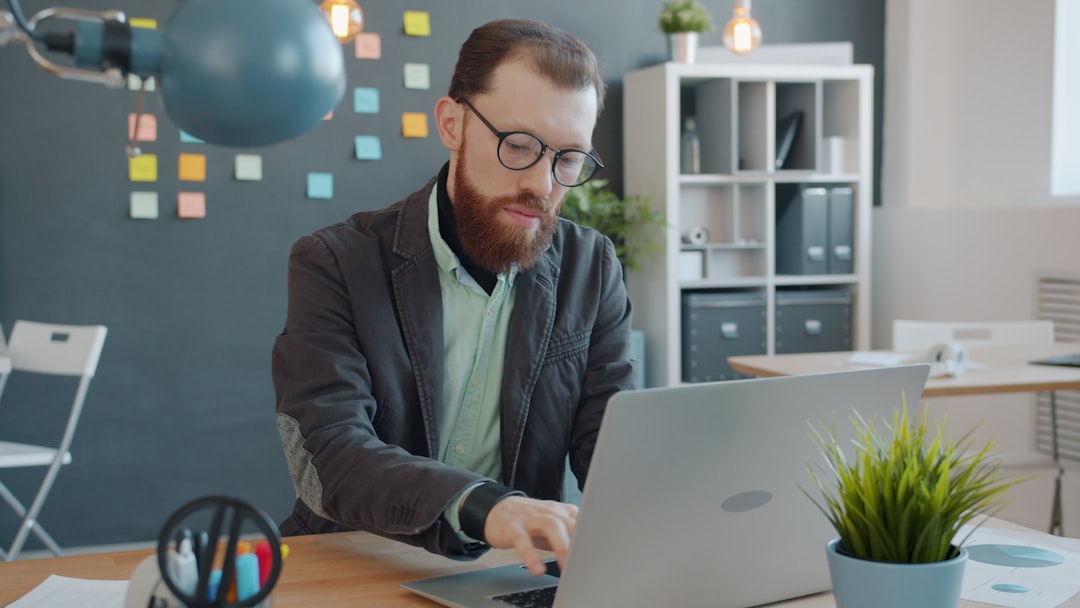 Financial analyst using AI tools on a laptop in a modern office environment