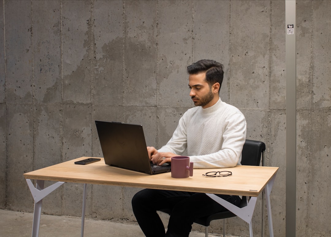 Professional studying AI certification on a laptop at a modern office desk