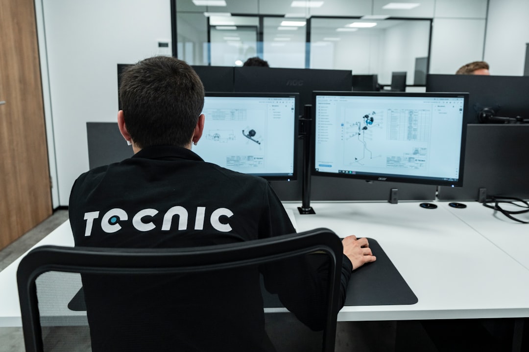 Automotive engineer working at a CAD design workstation with vehicle model on screen