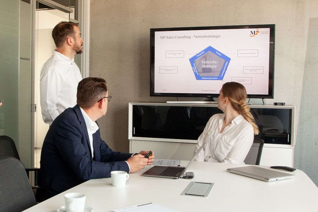 Sales team using CRM platform on laptops in a modern office environment